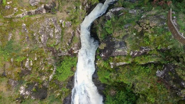 Landscape of Entrecruces Waterfall Flowing Through Rocks In A Coruna, Spain. drone tilt-down shot