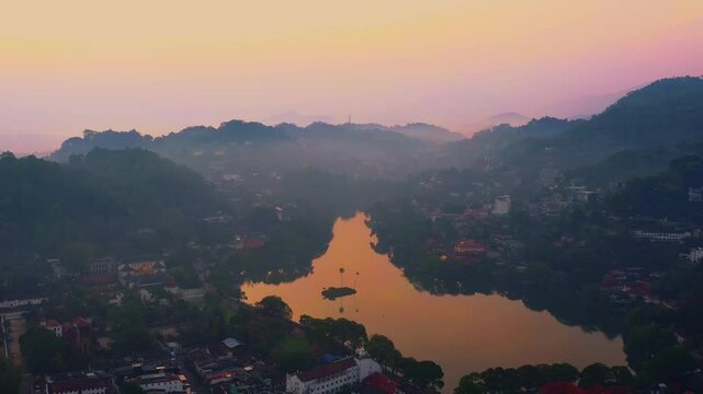 Aerial footage of Kandy City and Kandy Lake at sunset, with warm hues reflecting off the water. Capturing the peaceful, scenic charm of Sri Lanka s cultural capital, ideal for travel media.