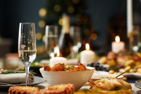 Background shot of baked potato wedges as side dish and champagne glass with sparkling drink served on festive dining table on Christmas Eve, copy space