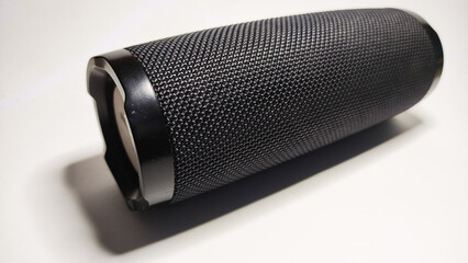 portable music in the shape of a cylinder, covered with black filter cloth using a Bluetooth connection