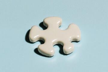 Obraz premium Close up of a single white jigsaw puzzle piece with space for text, copy or decoration.