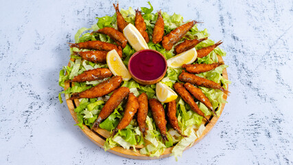 Fried Anchovy on lettuce with lemon