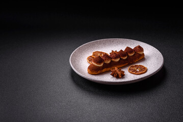 Sweet eclair with chocolate custard sprinkled with cocoa powder