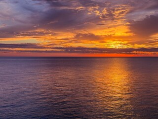 Fiery sunset sky over calm ocean 