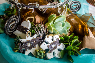 Nature inspired rustic summer Christmas centerpiece, composed of succulent plants, wooden ornaments and shiny fabrics.