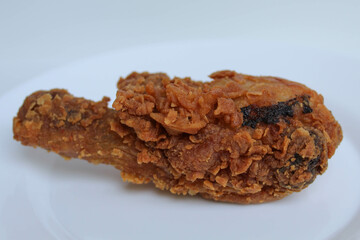 One crispy fried leg chicken, on white plate, isolated in white background