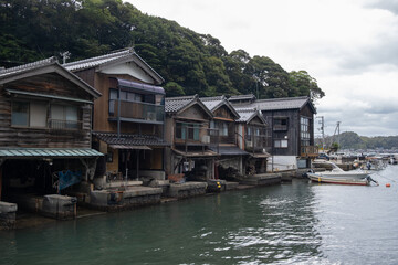 Fototapeta premium Ine Fishing Village, is famous for its unique funaya, or boat houses. These wooden buildings sit right on the water and serve as both dock and home for the fishermen