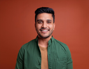 Fototapeta premium Portrait of Handsome Young Man Happily Smiling Against Colored Studio Background
