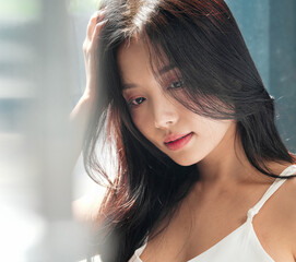 Fototapeta premium 自然光で撮影をした若い女性のビューティーポートレート