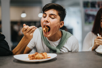 A teenager eagerly enjoying a meal at school cafeteria, showcasing excitement and satisfaction...