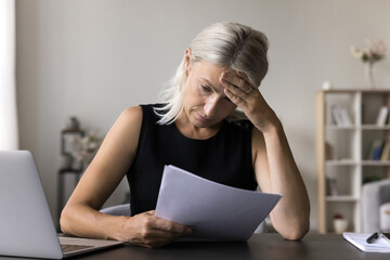 Confused upset older woman self employed entrepreneur think about financial debt possibility of...