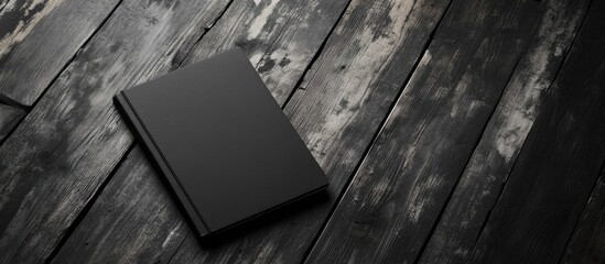 Dark black and white notebook on a wooden table backdrop Notebook against a black and white background. with copy space image. Place for adding text or design