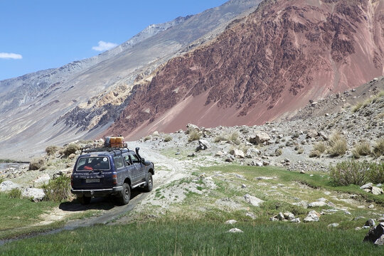 Off-road vehicles travel along the track along the Bartang Valley in the Gorno-Badakhshan region in Tajikistan