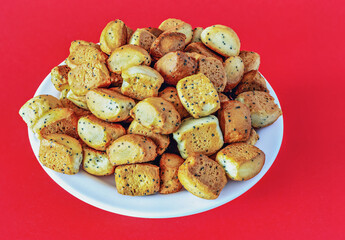 Christmas crisps with poppies in a plate on a red background