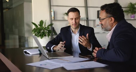 Client and manager presents detailed proposal to client during negotiation process in company office, showing visual data or presentation, provides information, review agreement terms using computer - Powered by Adobe