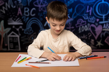 Naklejka premium Elementary school student with pencils, thoughtful expression, colorful school-themed chalkboard backdrop.