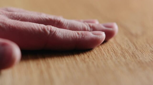 Slow motion man hand touch oil finished oak wood surface
