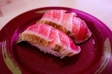 Top view of Japanese fresh Maguro Maki with Japanese rice in red plate, focus selective