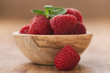 fresh raspberries in wood bowl on table