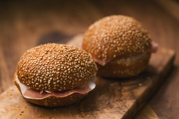 prosciutto and cream cheese in a sesame buns on wood board