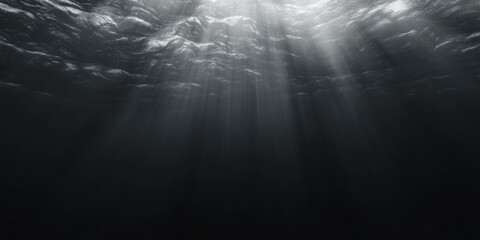 Obraz premium The image is of a dark ocean with a bright light shining through the water. Scene is serene and peaceful, as the light creates a calming atmosphere