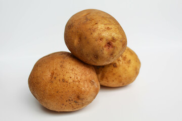 Fototapeta premium Three potatoes unpeeled, isolated on white background