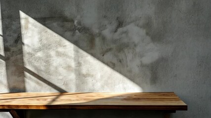 A wooden shelf sits against a concrete wall, bathed in the warm light of the morning sun - Powered by Adobe