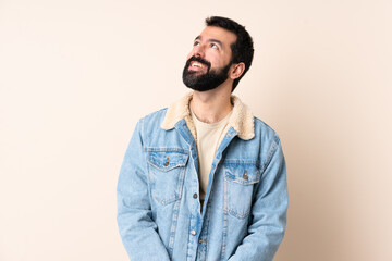 Caucasian man with beard over isolated background thinking an idea while looking up
