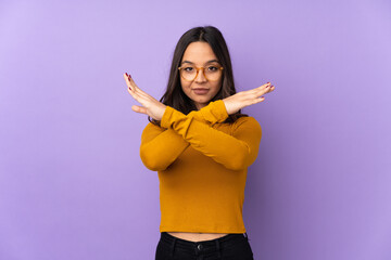 Young mixed race woman isolated on purple background making NO gesture