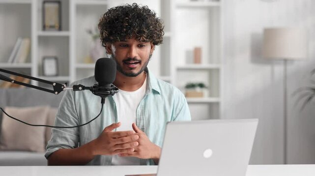 Microphone, podcast and Indian man speaker in his living room. Creative streamer, internet influencer or online content creator live streaming for audience.