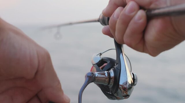 Man fishing with a spinning rod, close-up.