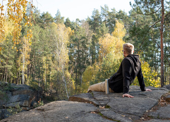 Fototapeta premium Man sitting on quarry edge enjoying nature view.