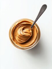 Spoonful of peanut butter is in a jar. The jar is on a white background