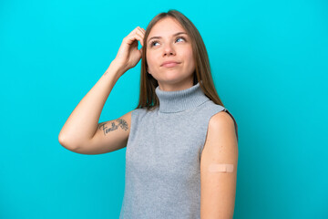 Young Lithuanian woman wearing band aids isolated on blue background having doubts and with confuse...