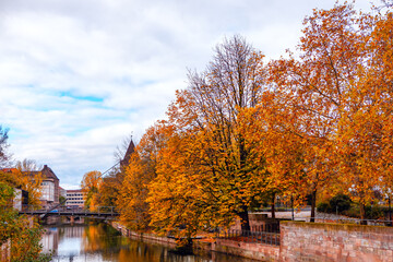 Autumn in Nuremberg, Serene river Pegnitz scene featuring a bridge. Weltherz fur Liebesschlosse