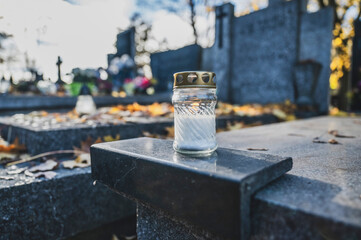 Lit Candle on a Grave Surrounded by Autumn Leaves During All Saints' Day in Poland