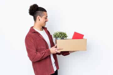 Caucasian man making a move while picking up a box full of things over isolated white background...