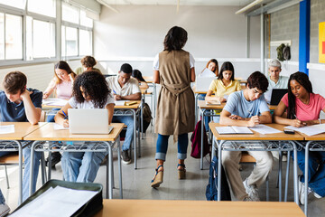 Diverse young group of high school students doing an exam at classroom. Education lifestyle and...