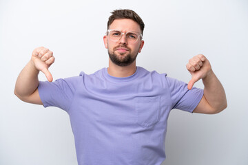Young caucasian man isolated on white background showing thumb down with two hands