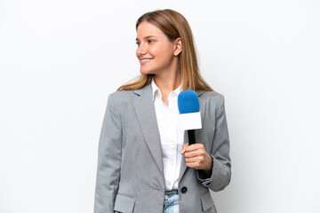 Naklejka premium Young caucasian tv presenter woman isolated on white background looking to the side and smiling
