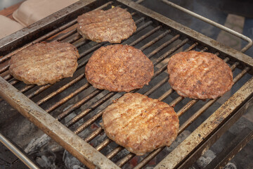 Burger meat steaks are cooked on hot coals.