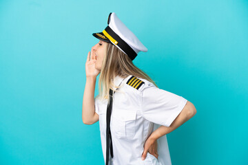 Airplane pilot over isolated blue background shouting with mouth wide open to the side