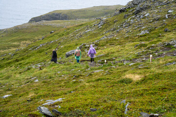 Skarsvag, Norway - 07.03.2024: Tourists on a trail to Kirkeporten in Norway