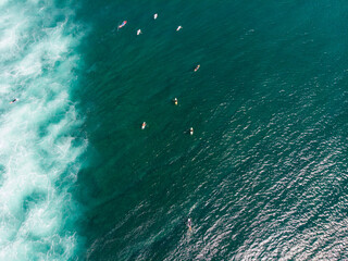 Surfers waiting for the perfect wave in the vast ocean.