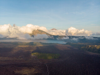 A serene view of a volcano surrounded by clouds and lush landscape.