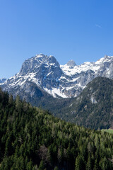 Obraz premium A majestic mountain range with snow-capped peaks under a clear blue sky.