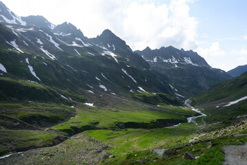 Obraz premium Spectacular mountain landscape with verdant valleys and rugged peaks beneath a bright sky.