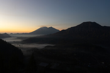 A serene sunrise over misty mountains.