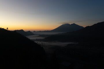 A serene mountain landscape at dawn with misty valleys.