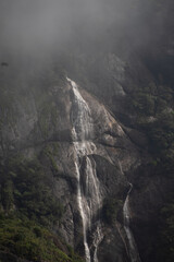 A majestic waterfall cascades down a misty mountainside.